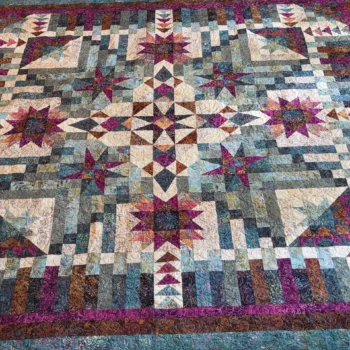 Intricate geometric quilt with star patterns.