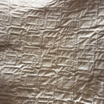 Beige fabric with embossed geometric pattern.