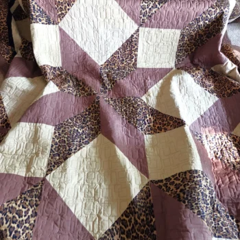 Geometric quilt with leopard print triangles.