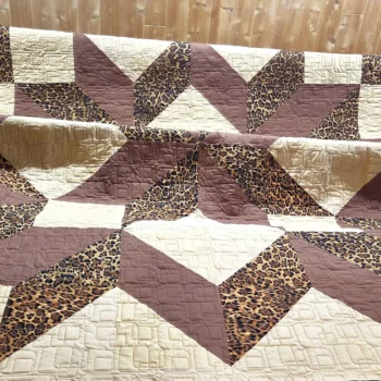 Quilt with brown and leopard star pattern.
