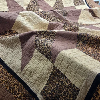 Patchwork quilt with star and leopard patterns.