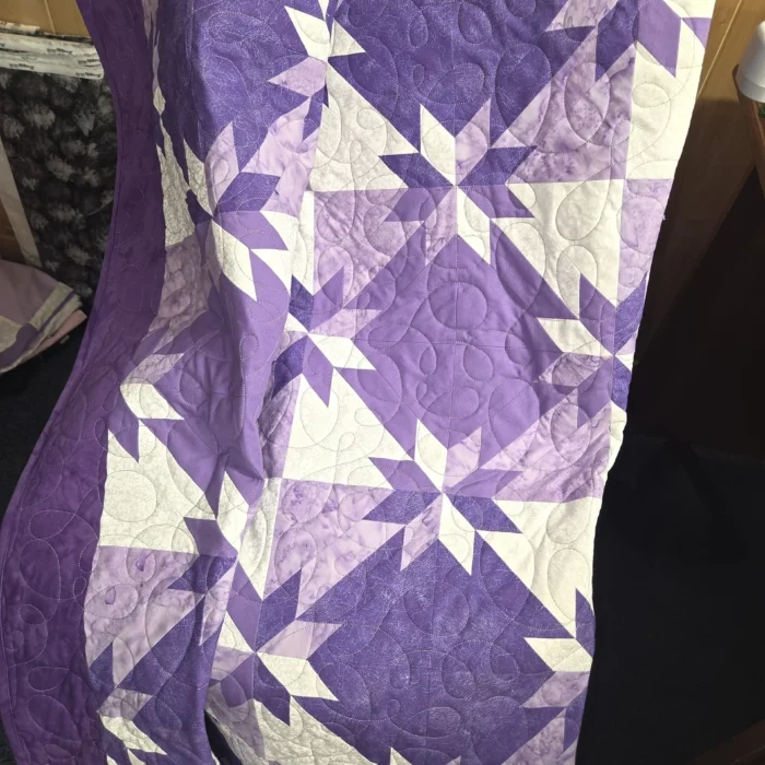 Purple and white star-patterned quilt.