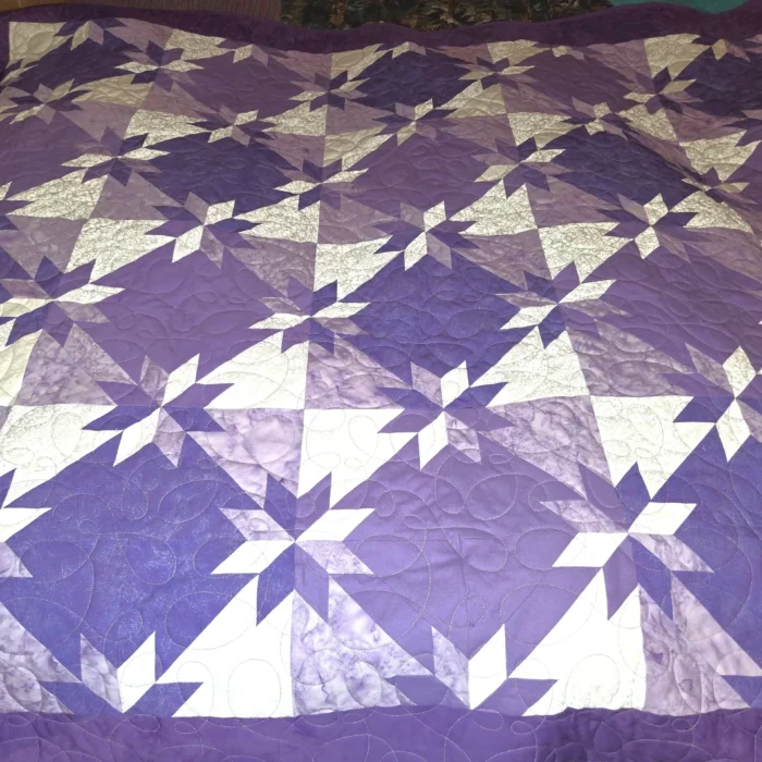Purple and white geometric pattern quilt.