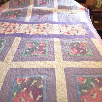 Colorful patchwork quilt on a bed.