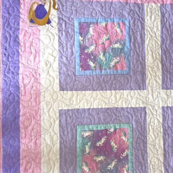 Quilt with unicorn and mermaid design.