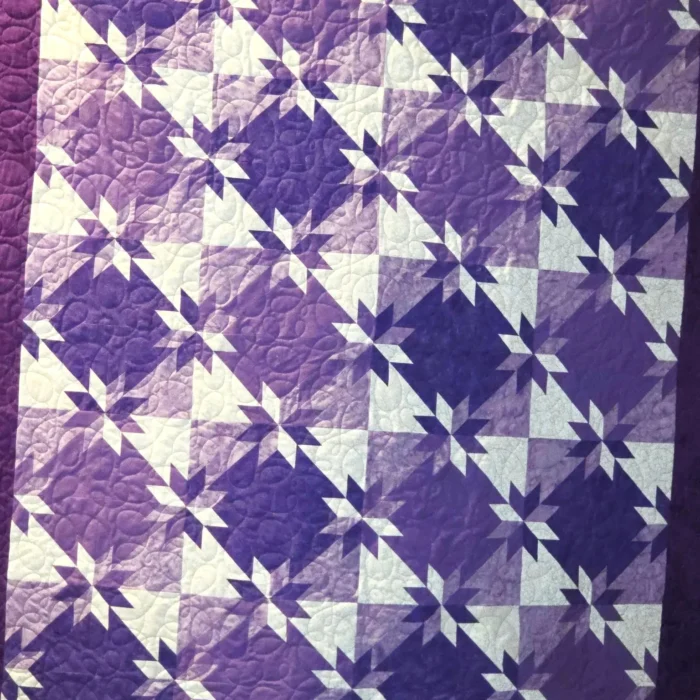 Purple and white geometric pattern quilt.